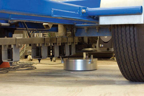 Floor-level view of the undercarriage of a falling-weight deflectometer unit being calibrated.