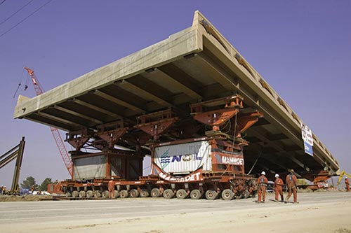 A stock photo shows the installation of a prefabricated bridge superstructure.