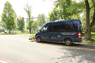 A stock photo shows a van equipped with nondestructive evaluation tools for detecting and assessing sensors embedded in roadway surfaces.