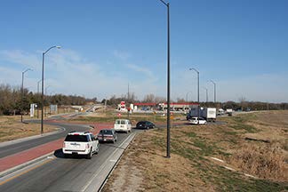 A stock photo shows several cars driving toward a roundabout.