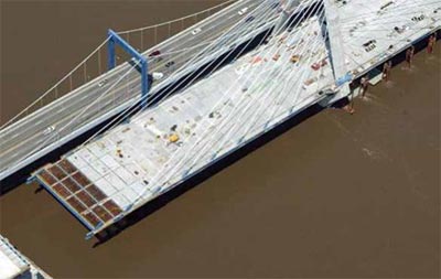 This figure shows construction of the roadway surface nearing completion on the Christopher Bond Bridge construction project in Kansas City, Missouri. The innovative side-by-side bridge constructive technique saved time and minimized road closures. (Image source: FHWA)