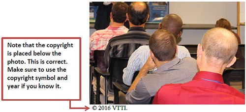 The photo is of an audience watching a presentation and shows an example of copyright treatment of a photo with copyright owned by an outside organization but never published. The significance of the photo is that directly below the photo, it shows the copyright symbol immediately followed by the year and the name of the company. This depicts a photo credit for this photo owned by a non-Federal Government organization.