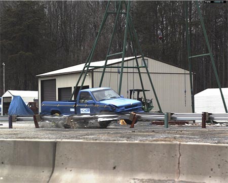 Photo of a crash test of a pickup truck impacting a w-beam guardrail at the Federal Outdoor Impact Lab at the Turner-Fairbank Highway Research Center