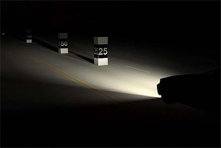 Photo of a carâ€™s headlights shining on distance markers labeled 25 and 50
