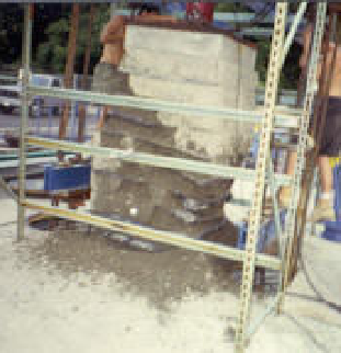 This photo shows the shear failure of a mini-pier experiments being conducted in an outdoor work area. A large soil mass is at the center of the photo, and people are working around the test setup.