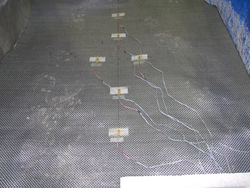 This photo shows a wide view of six strain gauges mounted on the geotextile using tape.