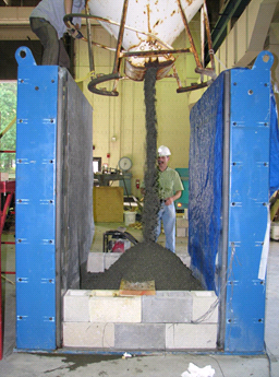 This photo shows a large machine releasing backfill into the test bin from above.