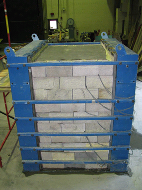 This photo shows the completed composite mass within the test bin. The modular facing blocks can be seen on the front of the mass, and there is an even layer across the top of the mass.