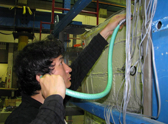 This photo shows a worker holding a tube to his ear to check for air leaks in the membrane.