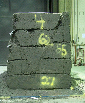 This figure shows one side of the test 4 composite mass after it was removed from the test bin. The mass shows two clear, diagonal failure planes, making a “V” shape on the side of the mass.