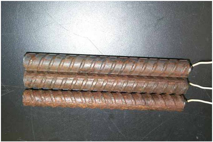 The three bars in the photo show that corrosion products, or rusting, are apparent, the extent of which increases with increasing exposure time.