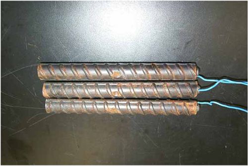 The three bars show that corrosion products are more apparent at the damage locations and at the bar ends than elsewhere along the length.