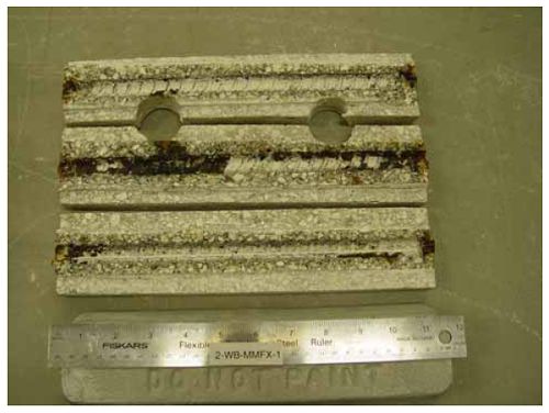 Heavy corrosion products are apparent along about one-half the length of one bar with lesser products along the remainder of the length. Small amounts of corrosion products are visible at the ends of the other two bars.