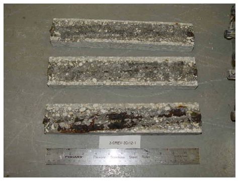 The photo shows minimal corrosion products on two traces and heavy corrosion products along the third.