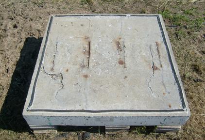 Corrosion products have caused cracking on the upper surface of the specimen. Corrosion products are evident near each of the four simulated cracks, as well as at multiple spots near the edge of the specimen and away from the simulated cracks.