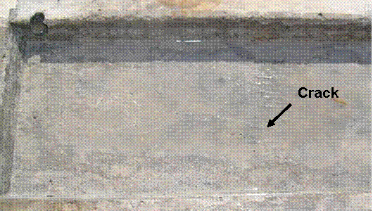 A faint white crack is observed over the length of the specimen. No staining on the surface is observed.