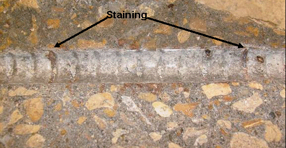 . Light staining is observed on the concrete around the regions where the epoxy was intentionally damaged.