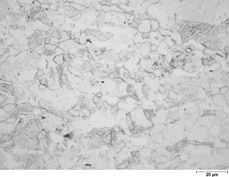 This photomicrograph shows an etched microstructure of an 11Cr plate from heat 67-V1-77 in the as-normalized condition zoomed to 500X. It shows randomly scattered grains of different shades of gray ranging from white to dark gray. Some of the gray grains have interior structure. The white grains have clear rounded boundaries, and the grain diameters are about the size of the scale mark. A scale mark about 15 percent of the length of the photo is marked 0.78 mil (20 microns).