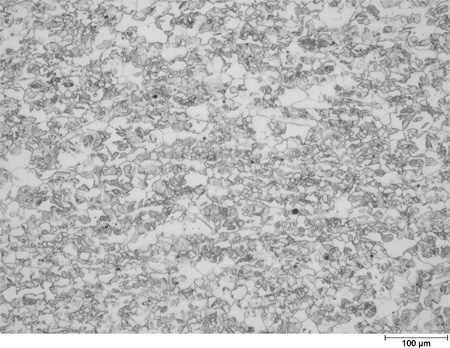 This photomicrograph shows an etched microstructure of a 9Cr2Si plate from heat 67-V1-71 in the as-normalized condition zoomed to 100X. It shows randomly scattered grains of different shades of gray ranging from white to black. A scale mark about 15 percent of the length of the photo is marked 3.9 mil (100 microns).