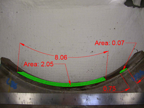 This photo shows the fracture surface. Fatigue cracks had started in two places. The larger crack has a total length of 8.06 inches along the outside diameter of the tube and a total area of 2.05 square inches. About 1 inch to the right of the primary crack is a smaller one that grew elliptically through half the pole wall thickness; it has a length of 0.75 inches on the outside diameter of the tube.