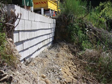 This photo shows that geosynthetic  reinforced soil walls can even be built with a negative batter and yet be  stable. This wall was constructed in New Zealand.