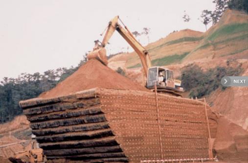 This photo shows that geosynthetic  reinforced soil walls can even be built with a negative batter and yet be  stable. This wall was constructed and load tested as shown in Japan.