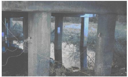 Seismic accelerometers on blocks bolted to piles of bent 2 of structure 4, Trinity River Relief Bridge. This image taken beneath the bridge shows seismic accelerometers attached to aluminum triaxial mounting blocks that are bolted to piles of bent 2 of relief structure 4 of the Trinity River Relief Bridge.