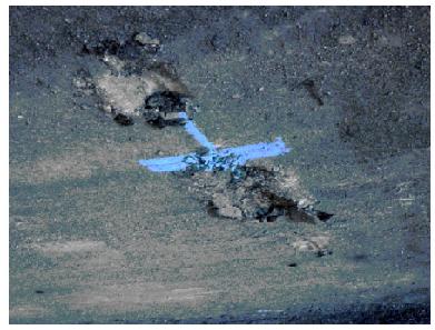 Dual-wheel depressions in asphalt overlay on deck over bent 2. This image shows depressions of the Vibroseis truck’s dual wheels in the asphalt overlay of the deck over bent 2.