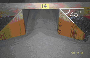 Figure 5. Rectangular model with wingwalls. Photo. This picture shows the rectangular model in figure 4 with wingwalls attached. The wingwalls are attached to the rectangle at a 45-degree angle, and sediment can be seen peaking in the middle of the rectangle, 14 inches from its top.