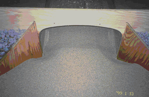 Figure 7. Conspan model with wingwalls. Photo. This picture shows the model in figure 6 with wingwalls attached. The sediment is distributed fairly evenly across the bottom of the shape.