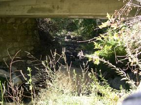 Figure 23. Dry Creek, Pacific Coastal-upstream under bridge, photo 1. Photo. This is looking upstream under the bridge at the rocky bed material and show good alignment with the bridge.