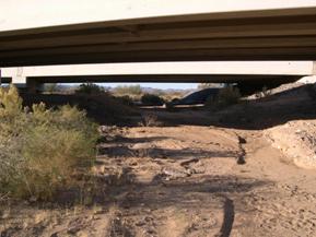 Figure 49. Sacramento Wash, Basin and Range-upstream under bridge. Photo. This is the Sacramento Wash in the Basin and Range region looking upstream from under the bridge. The bed material is loose sand and gravel, and the bank vegetation is nearly absent.