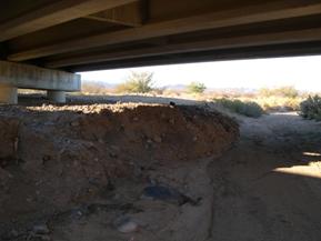 Figure 51. Sacramento Wash, Basin and Range-downstream under bridge. Photo. This is looking downstream under the bridge. The channel is completely dry and lacks definition.  Some channel mining is evident. 