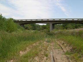 Figure 75. South Fork Solomon River, Great Plains-looking downstream at bridge, photo 1. Photo. This is the Solomon River in the Great Plains region looking downstream at the bridge. The bank vegetation consists of grasses and annuals, with woody vegetation several widths back from the banks.