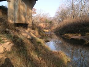 Figure 91. Unnamed creek (N 19), Central Plains-upstream under bridge. Photo. This is looking upstream under the bridge. Bank widening and bed degradation threaten the bridge. 