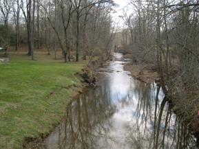 Figure 97. Honey Run, Interior Low Plateau-upstream from bridge. Photo. This is Honey Run in the Interior Low Plateau region looking upstream from the bridge. Bank vegetation has been removed on the right bank and there mass wasting is occurring. Elsewhere, woody vegetation holds the banks in place. 