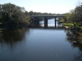 Figure 130. Peace River, Atlantic Coastal Plain-looking downstream at bridge. Photo. This is looking downstream toward the auto bridge. The channel is well-aligned with the bridge, and the flow is very calm. 