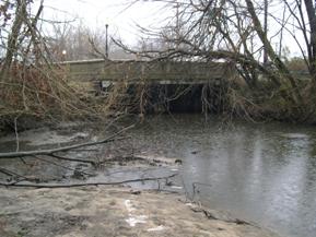 Figure 144. Mill Stream Branch, Atlantic Coastal Plain-looking upstream at bridge. Photo. This is looking upstream at the bridge. It is overwidened, and sediment has deposited downstream of the bridge.