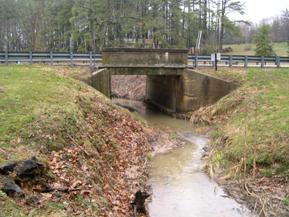 Figure 148. Kent County Tributary, Atlantic Coastal Plain-looking upstream at bridge. Photo. This is looking upstream at the bridge. The channel is deep due to degradation, and the banks are not stable.