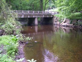 Figure 168. Aspetuck River, New England-looking downstream at bridge. Photo. This is looking downstream at the bridge. The right bank stabilized with rock.