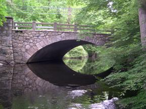Figure 175. Mianus River, New England-looking downstream at bridge. Photo. This is looking downstream at the arched stone bridge. Flow is aligned with the bridge, although the channel width is slightly larger than the bridge opening. 