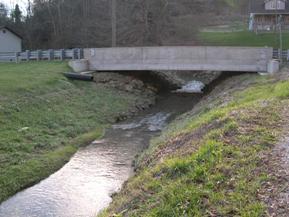 Figure 179. McKnown Creek, Appalachian Plateau-downstream from bridge. Photo. This is looking downstream from the bridge. There is only grass on the left bank with riprap for stabilization. 