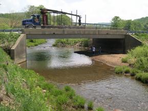 Figure 200. Sandy Creek, Appalachian Plateau-looking upstream at bridge. Photo. This is looking upstream at the bridge, again showing that lateral movement has caused the thalweg to press against the right abutment.