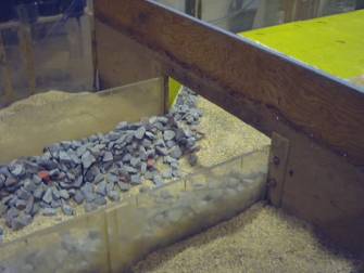 Figure 52. Photo. Shifted riprap in culvert barrel after Standard Plan test. The photo shows that the flow has moved some of the riprap into the scour holes created by the flow.