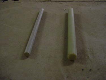 Figure 3. Photo. FRP dowels (2.54 and 3.81 cm (1.0 and 1.5 inches) in diameter). 
The photo shows two circular glass fiber reinforced polymer (FRP) dowel bars used in this research, with diameters of 2.54 and 3.81 cm (1.0 and 1.5 inches) and a length of 45.72 cm (18 inches). They were manufactured through a pultrusion process using continuous E-glass filaments and polyester resins. 
 