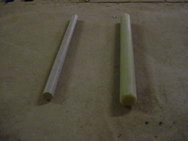 Figure 3. Photo. FRP dowels (2.54 and 3.81 cm (1.0 and 1.5 inches) in diameter). 
The photo shows two circular glass fiber reinforced polymer (FRP) dowel bars used in this research, with diameters of 2.54 and 3.81 cm (1.0 and 1.5 inches) and a length of 45.72 cm (18 inches). They were manufactured through a pultrusion process using continuous E-glass filaments and polyester resins. 
 