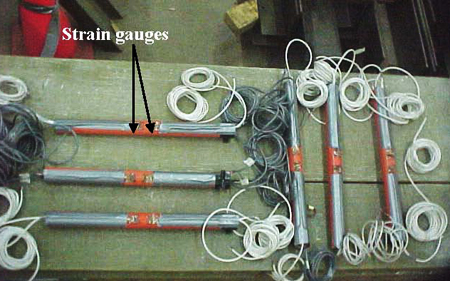 This photo shows six fiber reinforced polymer (FRP) dowel bars instrumented with strain gauges positioned on the top of dowels on both sides of mid-length monitoring strains in the pavement following their installation. 