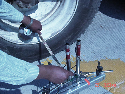 In this photo, the distance of linear variable differential transformer (LVDT) from the West Virginia Department of Transportation truck tire is measured because the embedded dowel on which the LVDT is placed is away from the tire. 
