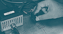 The photo shows an eddy current array sensor scanning a steel test plate with a defect.