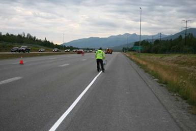 This photo shows a worker installing a white edge line on an Alaskan roadway in 2006.